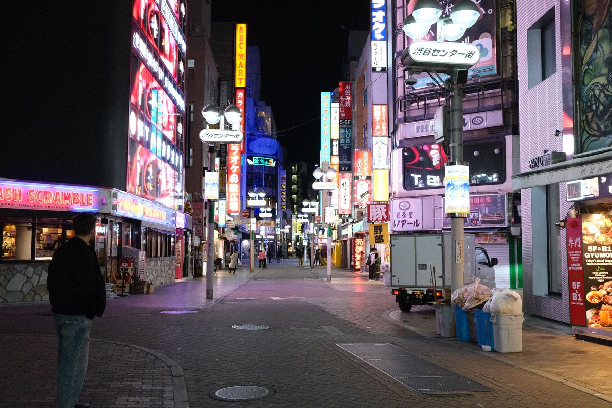 Strada di Shibuya piena di neon di notte